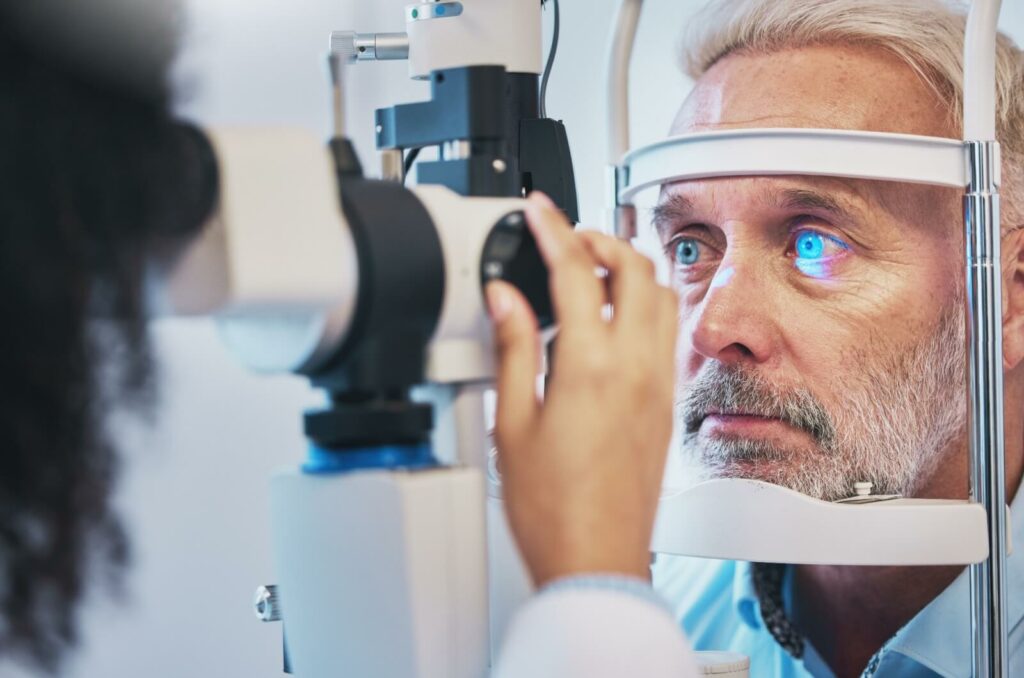 a man is at his optometrist's office for an eye exam to detect any underlying diseases.