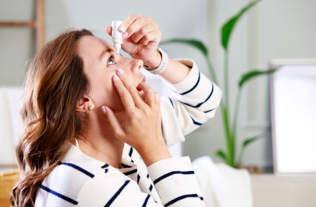 A person administering eye drops to alleviate their dry eye symptoms.